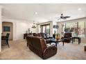 Open-concept living room features leather furniture, ceiling fan, with a window view at 13300 E Via Linda Dr # 1058, Scottsdale, AZ 85259
