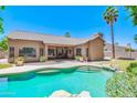 Inviting backyard pool with lush landscaping, rock features, and view of house and patio at 1470 W Bartlett Way, Chandler, AZ 85248