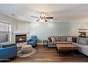 Spacious living room boasts wood floors, a ceiling fan, and cozy fireplace at 1505 N Center St # 218, Mesa, AZ 85201