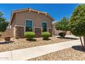 Landscaped front yard featuring stone accents, desert landscaping, and mature trees at 16785 W Montana De Oro Dr, Surprise, AZ 85387