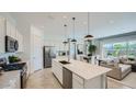 Spacious open kitchen with a large island, stainless steel appliances, and a view of the dining and living areas at 16895 W Bronco Trl, Surprise, AZ 85387