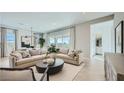 Open concept living room with neutral colors, comfortable seating, and large windows overlooking the backyard at 16895 W Bronco Trl, Surprise, AZ 85387