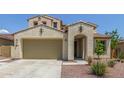 Inviting beige stucco home with a well-manicured desert landscape, a spacious garage, and a welcoming arched entrance at 19022 W Shangri La Rd, Surprise, AZ 85388