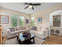Cozy living room featuring neutral decor, comfortable seating, ceiling fan, and bright windows at 2031 N 77Th Ln, Phoenix, AZ 85035