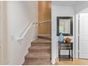 Carpeted staircase with white railing and wall decor, leading to the upper level at 2031 N 77Th Ln, Phoenix, AZ 85035