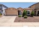 Charming single-story home with a well-manicured front yard and a two-car garage on a bright sunny day at 2177 W Agrarian Hills Dr, San Tan Valley, AZ 85144