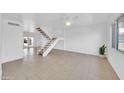 Spacious living room featuring tile flooring, plenty of natural light, and a staircase to the upper level at 2812 E Clarendon Ave, Phoenix, AZ 85016