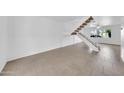 Bright living room with tiled floors and a modern white staircase leading to the upper level with lots of light at 2812 E Clarendon Ave, Phoenix, AZ 85016