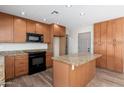 Kitchen with wood cabinets, a granite countertop, and a central island at 2941 W Michigan Ave, Phoenix, AZ 85053