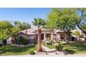 Beautiful single-story house with manicured lawn, mature landscaping, and circular driveway at 6428 W Eugie Ave, Glendale, AZ 85304