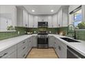 Modern kitchen featuring sleek cabinetry, stainless steel appliances, and stylish backsplash at 6723 E 1St Ave, Scottsdale, AZ 85251