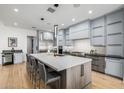An open kitchen showcases a large island with bar stool seating and modern gray cabinetry for a clean, contemporary look at 7851 N Central Ave, Phoenix, AZ 85020