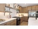 Contemporary kitchen with white countertops, wooden cabinetry, stainless steel appliances and tile backsplash at 8000 W Griswold Rd, Peoria, AZ 85345