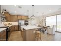 Open concept kitchen featuring stainless steel appliances, kitchen island with seating, and adjacent dining area at 8000 W Griswold Rd, Peoria, AZ 85345