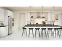 Modern kitchen featuring a large island with barstool seating, white cabinets, and stainless steel appliances at 8024 W Griswold Rd, Peoria, AZ 85345