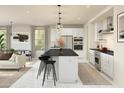 Open-concept kitchen showcasing an island with seating, stainless appliances, and seamless transition to the living space at 8024 W Griswold Rd, Peoria, AZ 85345