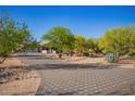 Desert home with a long driveway surrounded by lush greenery, and xeriscaping at 9432 E Quail Trl, Carefree, AZ 85377