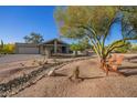 Desert home featuring a long driveway, xeriscaping, and wood Adirondack chairs at 9432 E Quail Trl, Carefree, AZ 85377