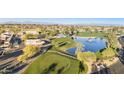 Breathtaking aerial view of a golf course community with lush green fairways, water features and distant mountains at 10102 E Michigan Ave, Sun Lakes, AZ 85248