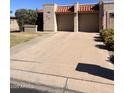 Spacious two-car garage with a wide driveway and beautifully landscaped front yard at 10102 E Michigan Ave, Sun Lakes, AZ 85248