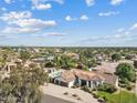 Wide aerial shot showcases the home's surroundings, including a pool and neighborhood at 10205 E Corrine Dr, Scottsdale, AZ 85260