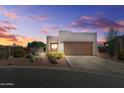 Contemporary home exterior with desert landscaping, and a two car garage, under a colorful sky at 10607 E Hillside Mine Ct, Gold Canyon, AZ 85118