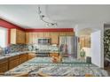 Well-lit kitchen featuring stainless steel appliances, granite countertops, and stylish backsplash at 1937 W Burgess Ln, Phoenix, AZ 85041