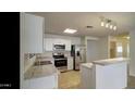 Bright kitchen features stainless steel appliances and white cabinetry at 218 E Milada Dr, Phoenix, AZ 85042