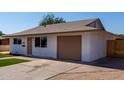Side view of an updated single-story home with an attached garage and clean landscaping at 2443 E Randall Dr, Tempe, AZ 85288