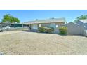 View of a single-story home with a gray exterior, low-maintenance front yard, and covered carport at 3107 W Lisbon Ln, Phoenix, AZ 85053