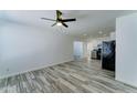 Bright living room featuring sleek wood-look tile flooring and open access to kitchen area at 3107 W Lisbon Ln, Phoenix, AZ 85053