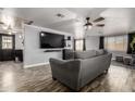 Comfortable living room with gray sofa, modern entertainment center, and stylish luxury vinyl plank flooring at 3807 W Abraham Ln, Glendale, AZ 85308