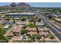 Aerial shot of property featuring a gorgeous home, manicured lawns, and a tree-lined street at 3812 E Camelback Rd, Phoenix, AZ 85018