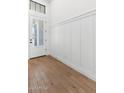 Bright entryway featuring wood floors, board and batten wainscoting, and a glass paneled front door at 4451 N 203Rd Ave, Buckeye, AZ 85396
