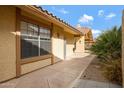 A walkway lined with landscaping along the side of a light colored single-story home with a terra cotta roof at 4790 E Navajo St, Phoenix, AZ 85044