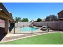 A refreshing swimming pool is surrounded by secure fencing and well manicured landscaping at 537 S 153Rd Ln, Goodyear, AZ 85338