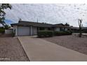 Attractive single-story home showcasing desert landscaping and a concrete driveway leading to a garage at 5720 E University Dr, Mesa, AZ 85205