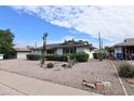 Frontal view of a single-story home displaying desert landscaping and a well-maintained yard at 5720 E University Dr, Mesa, AZ 85205