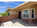 Inviting front porch with tiled flooring, brick accents, and a cozy seating area with flowers at 6546 E Dallas St, Mesa, AZ 85205