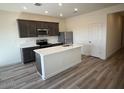 Modern kitchen featuring an island, stainless steel appliances, and dark wood cabinetry at 658 S Maricopa Rd, Florence, AZ 85132