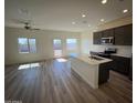 Bright, open-concept living area with a kitchen island, lots of natural light, and wood flooring at 658 S Maricopa Rd, Florence, AZ 85132