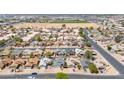 An aerial view showcasing the neighborhood with well-maintained landscaping, surrounding residences and open spaces at 6938 W Nicolet Ave, Glendale, AZ 85303