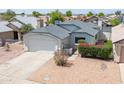 Charming single-story home with a two-car garage and low maintenance desert landscaping in front yard at 6938 W Nicolet Ave, Glendale, AZ 85303