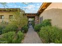 Charming entryway, desert landscaping and tile walkway leading to the home entrance with beautiful courtyard views at 7846 E Wilderness Trl, Gold Canyon, AZ 85118