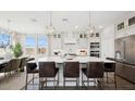 A spacious kitchen with a large center island with seating, stainless steel appliances, and elegant pendant lighting at 8030 W Griswold Rd, Peoria, AZ 85345