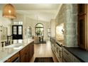 Gourmet kitchen boasting a stone accent wall, large island, stainless appliances, and seamless flow to dining area at 8910 E Topeka Dr, Scottsdale, AZ 85255