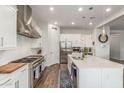 Well-lit kitchen boasts stainless steel appliances, white cabinetry, and a large island with sink at 9764 E Thornbush Ave, Mesa, AZ 85212