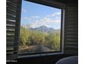 Picture window frames an exquisite view of the landscape and mountain range with a blue sky at 10284 E Mallow Cir, Scottsdale, AZ 85255
