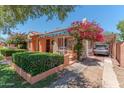 Lovely exterior of home with colorful accents, mature landscaping, and a covered carport at 1134 W Portland St, Phoenix, AZ 85007