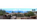 Charming backyard with a stone fireplace and built-in seating, offering stunning mountain views and desert landscaping at 136 E Desert Wind Dr, Phoenix, AZ 85048